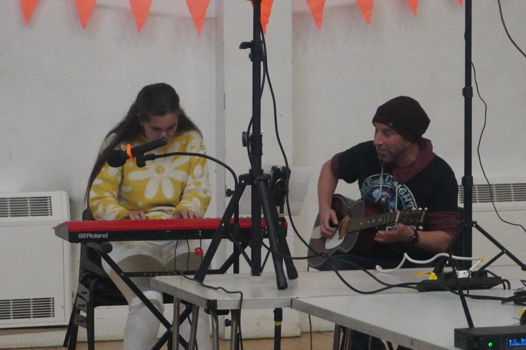 Holly playing the keyboard and Richard playing the guitar