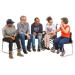 A diverse group of five people sitting and talking together, with one person in a wheelchair.