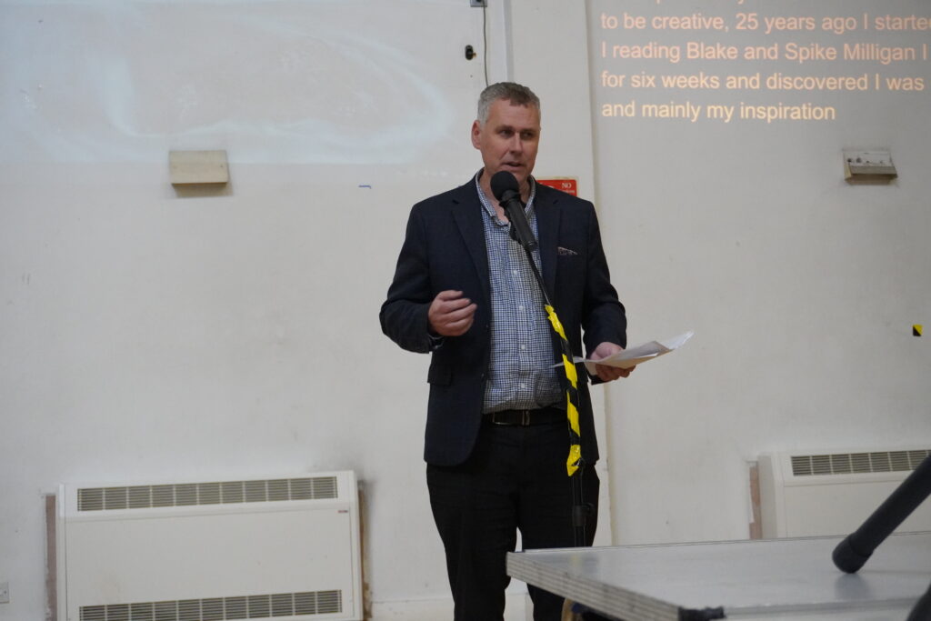 Ian Forrest reading his poem in front of a microphone