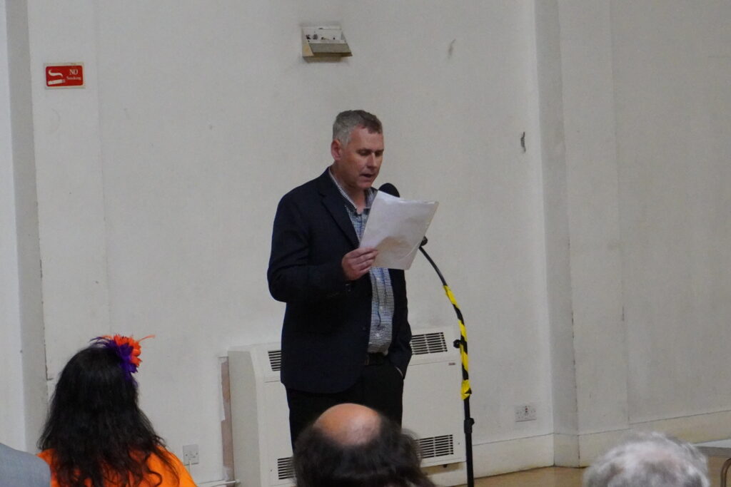 Ian Forrest reading his poem in front of a microphone