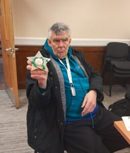 Attendee holding up a tea light holder made in the session.